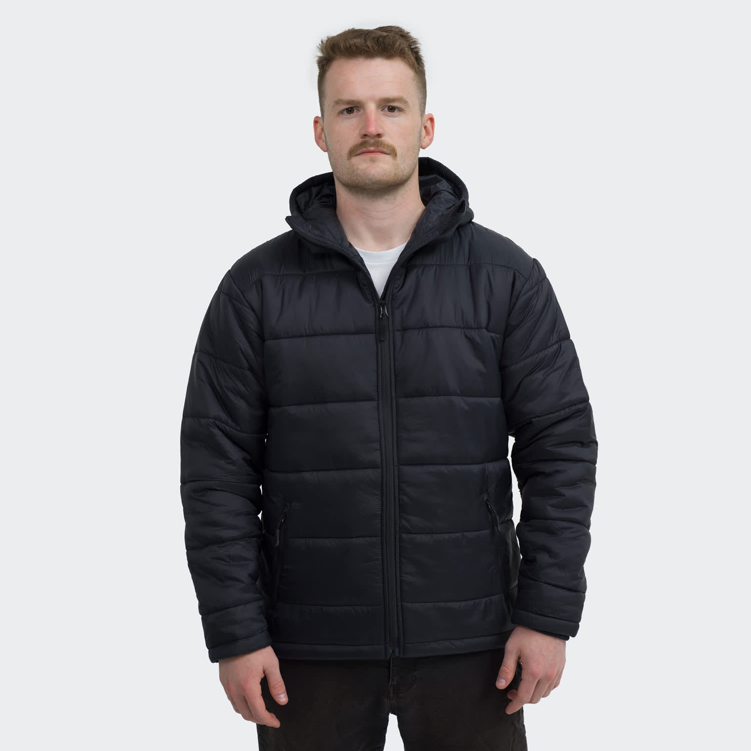 A black puffer jacket with a hood and zip, worn by a man standing against a neutral background. TRENDSWEAR Milford Mens Puffer Jacket - Image 1