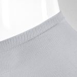 A pair of grey ankle socks displayed on a mannequin. The socks feature a ribbed design and a branding logo.
