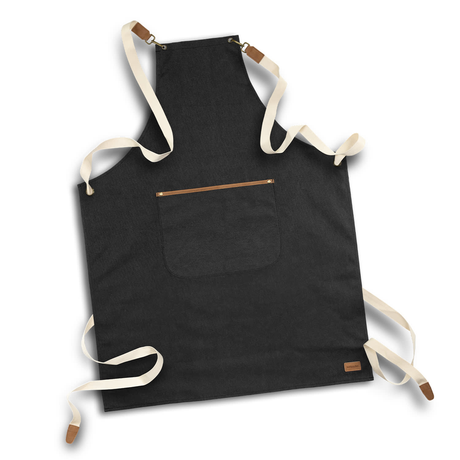 A black canvas apron with cream-coloured straps and a pocket at the front. Features a logo on the bottom corner. Keepsake Canvas Apron - Image 1