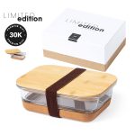 A glass lunch box with a bamboo lid and a cork base, packaged in a stylish box. It features a logo.