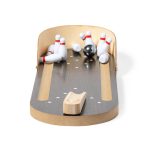 A wooden minigame bowling setup features a lane, a black bowling ball, and scattered white pins with red stripes.