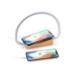A wireless charger lamp with a sleek white arch design and a wooden base, featuring two smartphones charging.