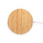 A round bamboo wireless charger with a minimalist design and a white charging cable attached.