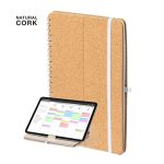 A cork notebook with a wire spiral binding, featuring an elastic band, next to a tablet displaying a calendar.