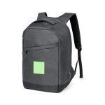 A grey anti-theft backpack with padded straps and a logo. It features a front zip pocket and a square patch.