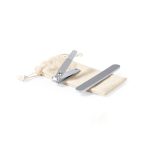 A silver nail clipper and nail file on a beige pouch. The set is designed for personal grooming.