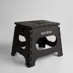 A black ASC Utility Stool with a textured surface and cut-out handles, featuring a logo on one side.