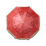 A beach umbrella featuring a vibrant watermelon design with red and green colours and black seed accents.