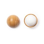 A circular lip balm with a textured wooden exterior and a smooth white balm inside, featuring a logo.