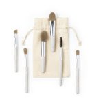 A set of six eyeshadow applicators with beige handles and silver ferrules, packaged in a cream-coloured drawstring bag.