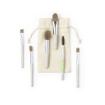 A set of six eyeshadow applicators with beige handles, displayed alongside a natural fabric pouch.