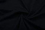 A black cotton T-shirt fabric twisted in a spiral pattern. The material appears smooth and flexible.
