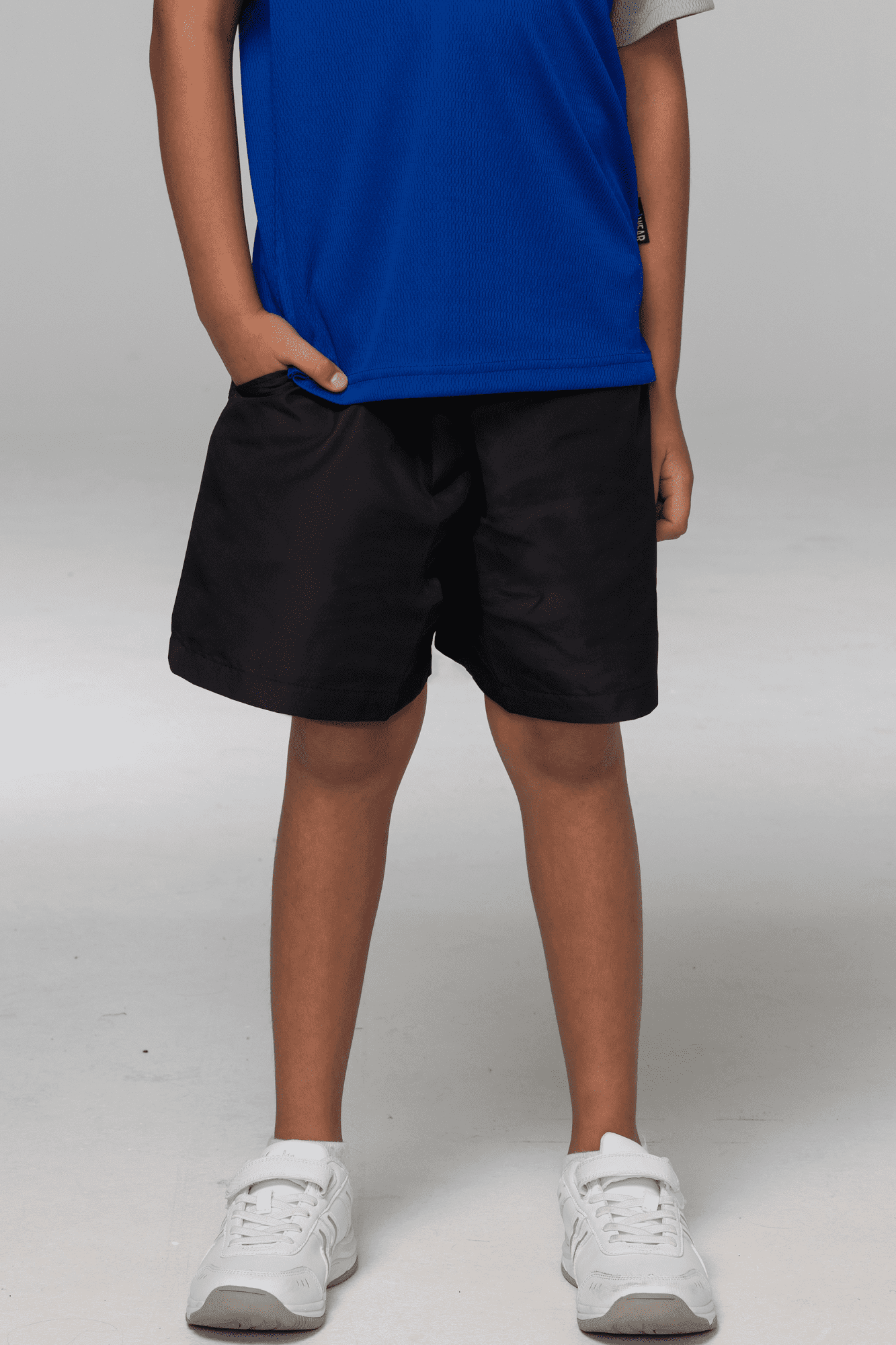 Black sports shorts for kids, featuring a relaxed fit and an elastic waistband, paired with a blue shirt. Black sports shorts for kids, featuring a relaxed fit and an elastic waistband, paired with a blue shirt.
