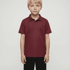 A maroon polo shirt designed for kids, worn by a child, paired with dark shorts. The shirt features a logo.