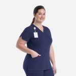 A curved V-neck top in navy blue with a pocket and a name tag holder. Features a logo on the left side.