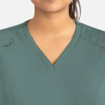 A women's curved V-neck top in a soft green colour, featuring a subtle logo on the shoulder.