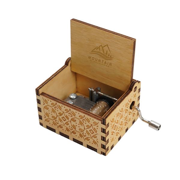 A wooden music box in natural wood tones, featuring intricate carvings and a metal winding handle. A wooden music box in natural wood tones, featuring intricate carvings and a metal winding handle.