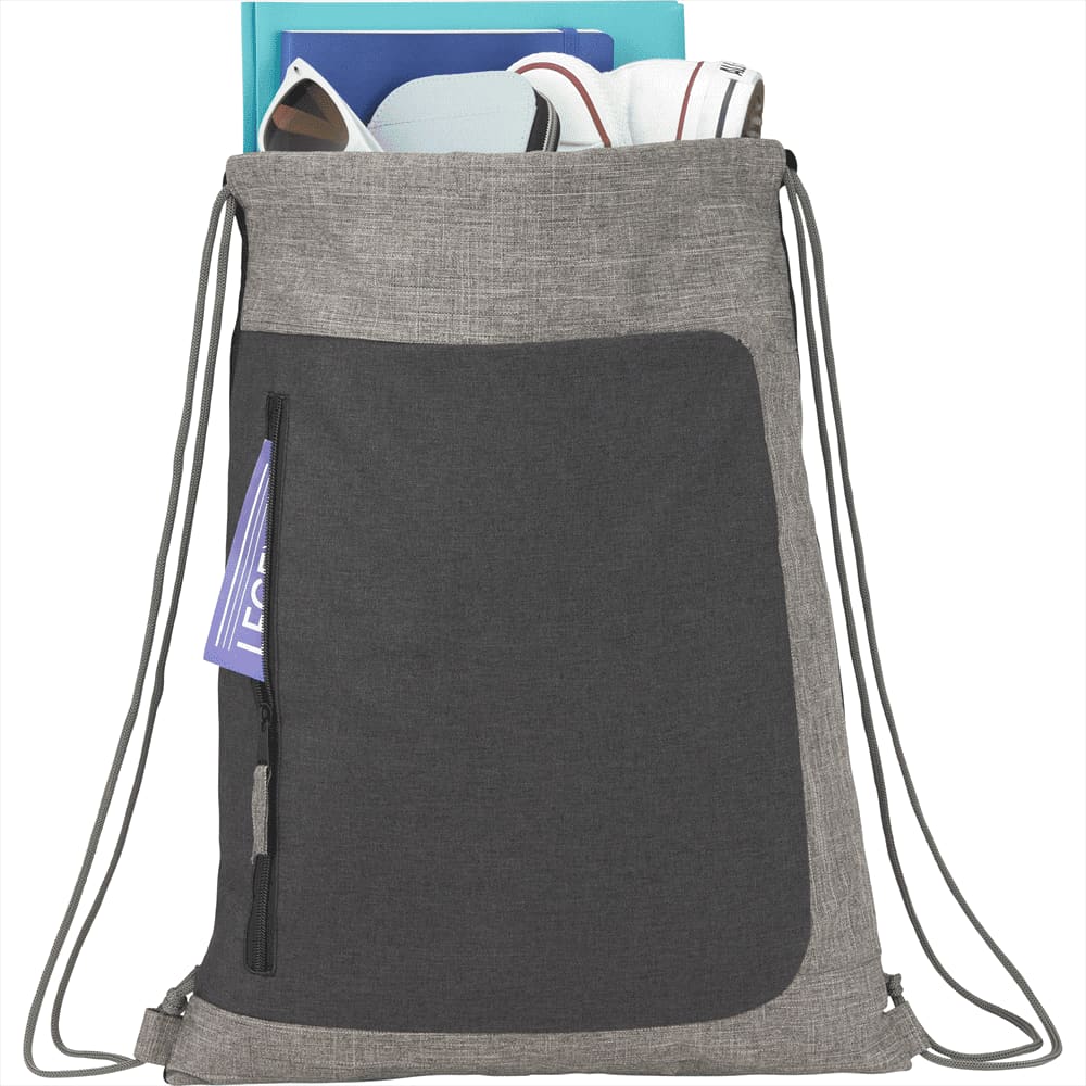A grey drawstring bag with a front pocket, containing various items, and featuring a logo. Reclaim Recycled Drawstring Bag - Image 1