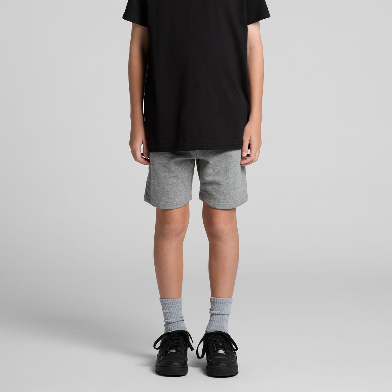 Youth stadium shorts in light grey, featuring a comfortable fit and a stylish design, paired with black shoes and grey socks. Youth stadium shorts in light grey, featuring a comfortable fit and a stylish design, paired with black shoes and grey socks.