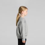 A grey sweater for kids, featuring a crew neck and long sleeves, displayed on a child from the side.