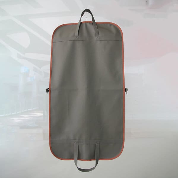 A hanging garment bag in grey with orange trim, featuring handles and a logo. A hanging garment bag in grey with orange trim, featuring handles and a logo.