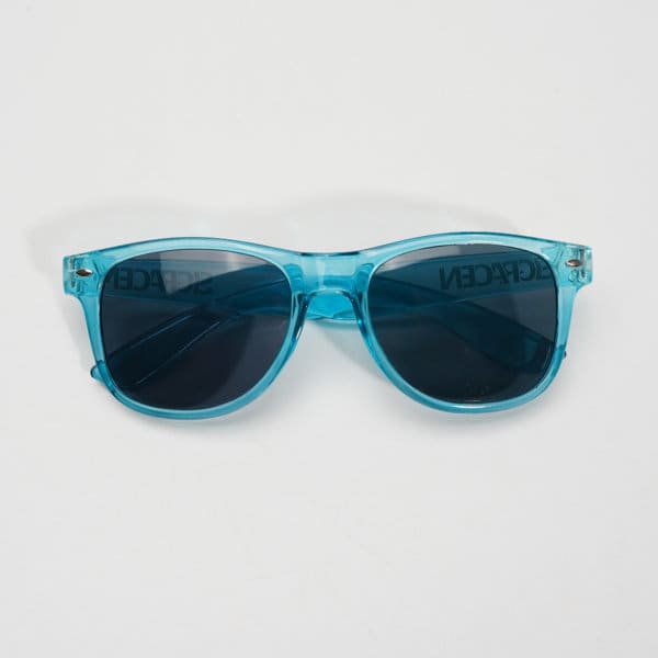A pair of blue fashion sunglasses with dark lenses and a light blue transparent frame, featuring a logo on the side. A pair of blue fashion sunglasses with dark lenses and a light blue transparent frame, featuring a logo on the side.
