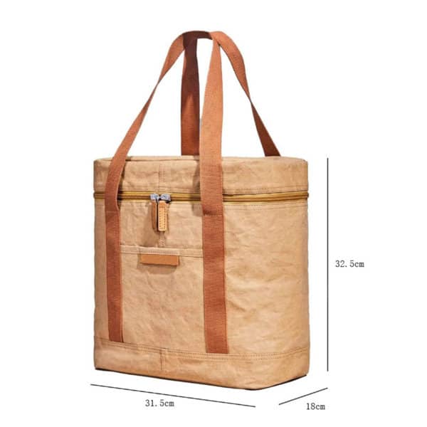 A tan insulated lunch bag with brown straps, featuring a zip closure and a front pocket. It has a branding logo. A tan insulated lunch bag with brown straps, featuring a zip closure and a front pocket. It has a branding logo.