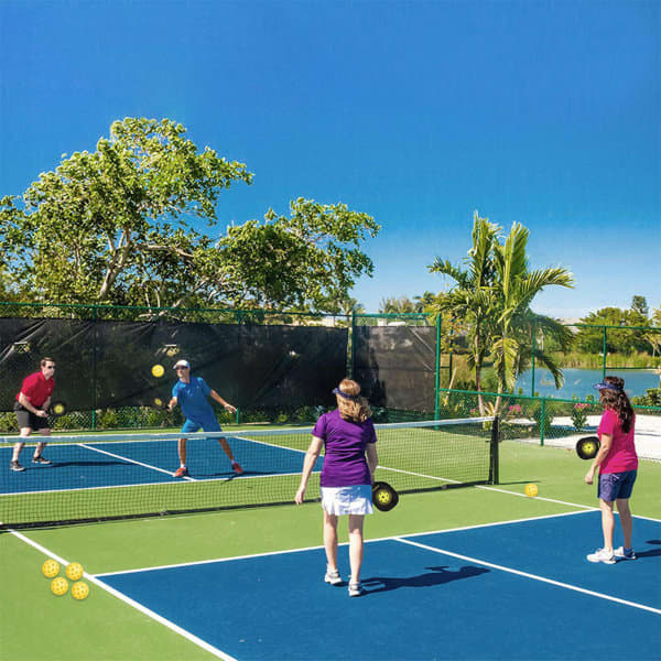 A vibrant outdoor scene featuring four people playing pickleball on a blue and green court surrounded by greenery. A vibrant outdoor scene featuring four people playing pickleball on a blue and green court surrounded by greenery.