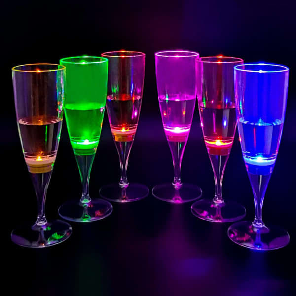 A set of seven LED light up champagne glasses in vibrant green, pink, and blue, glowing against a dark background. A set of seven LED light up champagne glasses in vibrant green, pink, and blue, glowing against a dark background.