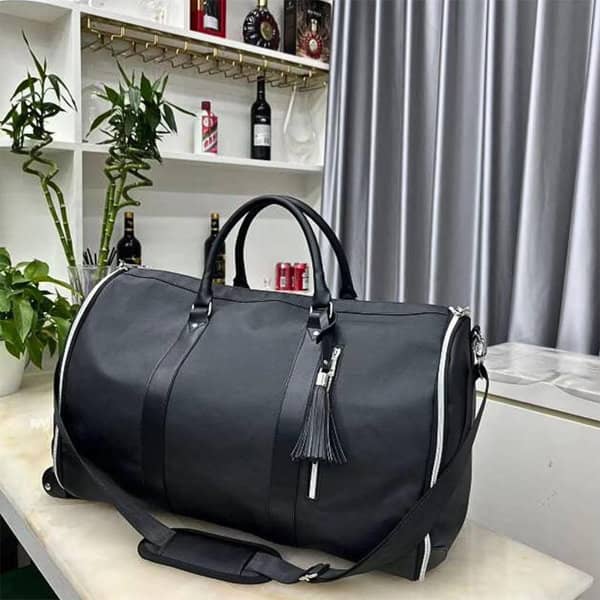 A black wheeled garment bag with a shoe compartment, featuring a zipper and a decorative tassel. A black wheeled garment bag with a shoe compartment, featuring a zipper and a decorative tassel.