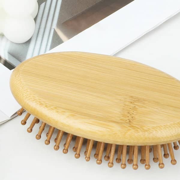 A bamboo massage comb with rounded edges and wooden bristles on a flat surface, surrounded by neutral tones. A bamboo massage comb with rounded edges and wooden bristles on a flat surface, surrounded by neutral tones.