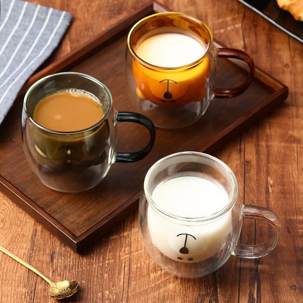 A set of three double wall glass coffee cups in various colours, featuring a black handle and a logo. A set of three double wall glass coffee cups in various colours, featuring a black handle and a logo.