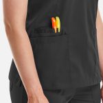 A women's black double V-neck top featuring a pocket with orange and green pens.