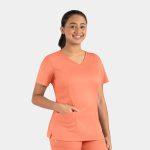 A model wears a coral Matrix Women's Double V-Neck Top with a pocket, featuring a logo on the side.