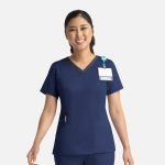 A navy blue double V-neck top with contrasting trim, featuring a logo and a name badge holder.