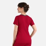 A red women's top with a contrast double V-neck and a branding logo, viewed from the back.
