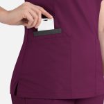 A women's plum-coloured top featuring a contrast double V-neck and a pocket for storage.
