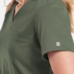 A women's v-neck top in olive green, featuring short sleeves and a chest pocket, with a small logo on the sleeve.
