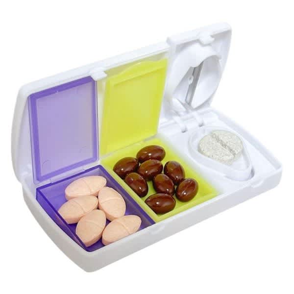 A white travel pill organizer with purple and yellow compartments, containing various shaped tablets and a pill cutter. A white travel pill organizer with purple and yellow compartments, containing various shaped tablets and a pill cutter.