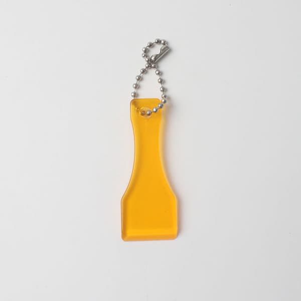 A yellow lottery scratcher keychain with a silver ball chain attached. A yellow lottery scratcher keychain with a silver ball chain attached.
