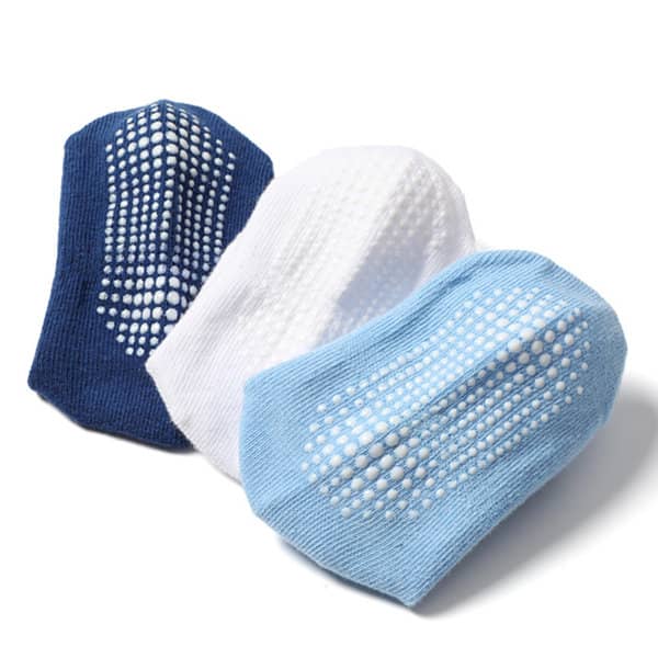 A set of three non-slip baby socks in navy blue, white, and light blue, featuring textured grip patterns. A set of three non-slip baby socks in navy blue, white, and light blue, featuring textured grip patterns.