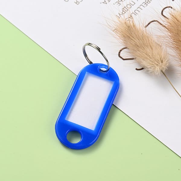 A blue custom key tag with a tang ring, featuring a clear central section for personalisation. A blue custom key tag with a tang ring, featuring a clear central section for personalisation.
