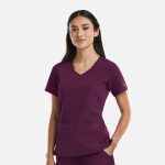A women's curved V-neck top in a deep purple colour, featuring a logo, with short sleeves and front pockets.