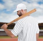 A man in a striped white baseball jersey and white cap holds a wooden baseball bat over his shoulder.