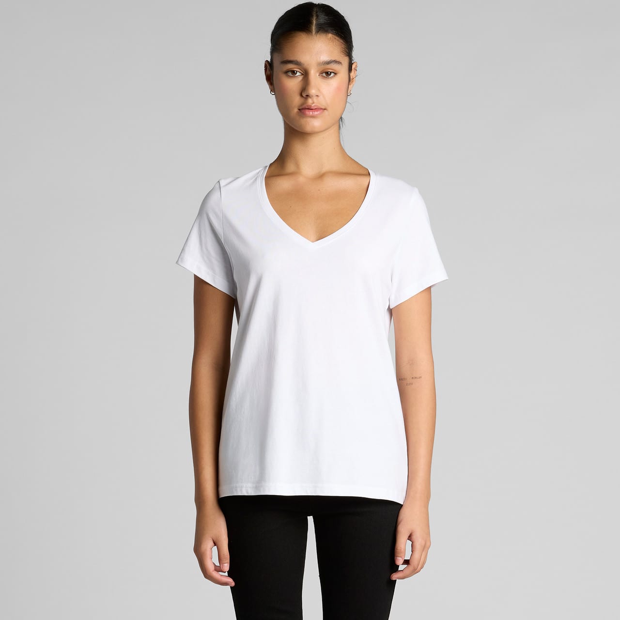 A white v-neck t-shirt featuring short sleeves and a relaxed fit. The shirt has a branding logo. A white v-neck t-shirt featuring short sleeves and a relaxed fit. The shirt has a branding logo.