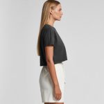 A cropped grey t-shirt with short sleeves, displayed on a model wearing white shorts, featuring a logo.