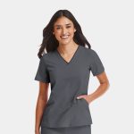 A women's grey V-neck top featuring a contrast design, displayed on a smiling model with a logo on the sleeve.