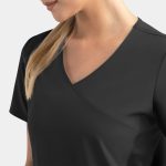 A mock wrap top in black with contrast panels, featuring a stylish V-neck design. The model has long hair.
