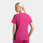 A women's mock wrap top in pink with contrast black panels, showcasing a sleek design from the back.