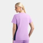 A mock wrap top in lavender with navy contrast panels and a logo on the back.